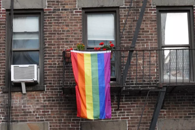 Pride flag hanging from a balcony. 